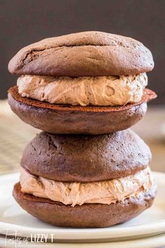 three chocolate donuts stacked on top of each other with frosting in between them