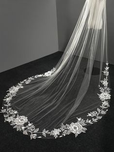 a wedding veil with flowers and leaves on the bottom is shown in black and white