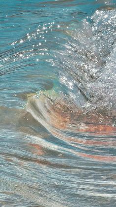 a person riding a surfboard on top of a wave in the ocean with blue water