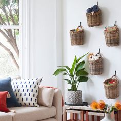 a living room filled with furniture and baskets on the wall