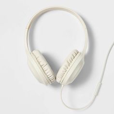 a pair of white headphones sitting on top of a table next to a cord