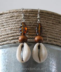 Handmade using natural cowrie shells and czech beads. Approximately 2.5 inches long. One of a kind earrings. Beach Wooden Bead Earrings, Brown Beaded Earrings For Beach With Dangling Beads, Brown Dangling Bead Earrings For Beach, Brown Beaded Dangling Earrings For Beach, Handmade Bohemian Brown Shell, Handmade Brown Bohemian Shell, Handmade Brown Cowrie Shell Jewelry, Handmade Brown Beaded Earrings For Beach, Bohemian Adjustable Cowrie Shell Earrings