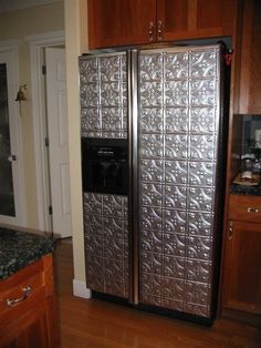 an image of a stainless steel refrigerator in the middle of a wooden floored kitchen