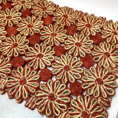 a red and gold rug with flowers on it