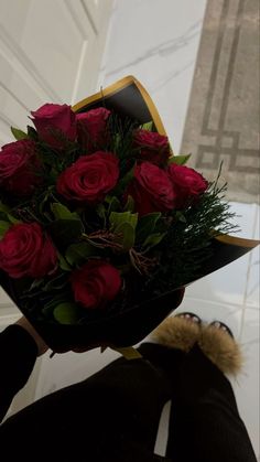 a person holding a bouquet of red roses