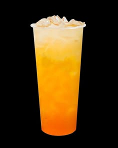 an orange and yellow drink with ice in it on a black background is seen from the side