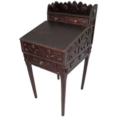 an antique wooden desk and chair with carved designs on the top, sitting side view