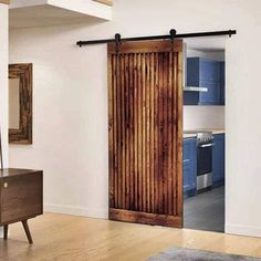 an open sliding door with wooden slats in the middle and blue cabinets on either side