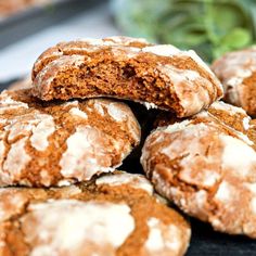 a pile of cookies sitting on top of a black plate next to a green plant