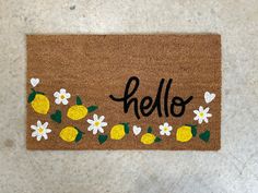 a door mat that says hello with lemons and daisies on the front side