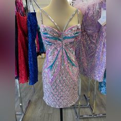 two dresses are on display in a store with purple, blue and pink sequins