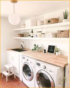 a washer and dryer sitting in a room next to each other with shelves above them