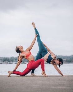 two women doing yoga on the beach with their hands in each other's pockets