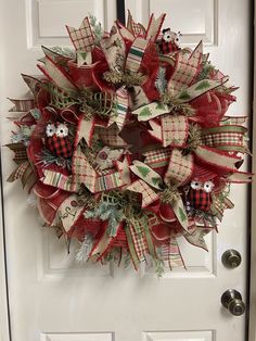 a red and white christmas wreath hanging on a door