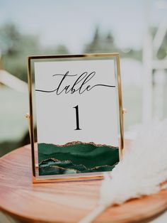 the table numbers were placed on top of each other, with gold frames and white feathers