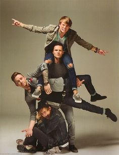 a group of young men posing for a photo with their arms around each other in the air