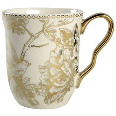 a white and gold coffee cup with a bird on the handle, decorated with flowers