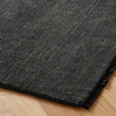 a close up view of a black rug on a wooden floor with wood floors and parquet boards