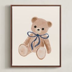 a brown teddy bear with a blue ribbon on it's neck hanging from a wall