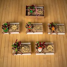 four small wooden boxes with christmas decorations on them sitting on a wood floor next to each other