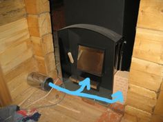 a wood burning stove with an arrow pointing to the right and blue arrows pointing up