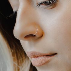 a close up of a woman's nose and nose piercing