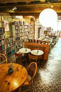 the inside of a library with tables, chairs and bookshelves full of books