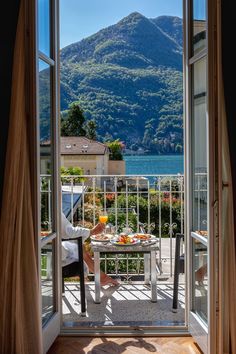 an open door leading to a balcony with a table and chairs in front of it