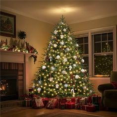 a christmas tree is lit up in the living room with presents under it and lights on