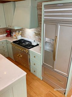 a metallic refrigerator freezer sitting inside of a kitchen next to a stove top oven