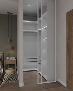 an empty white closet in a bedroom next to a bed