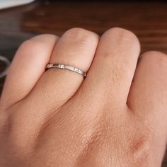 a woman's hand with a wedding band on top of her finger, next to a computer keyboard