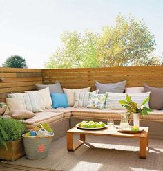 an outdoor living area with couches, tables and potted plants on the deck