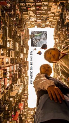 two men standing in front of a very tall building with lots of books on it