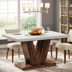 a dining room table with chairs and a plate of food on it in front of a window