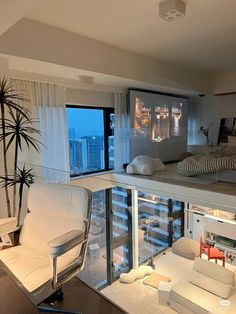 a living room with white furniture and large windows overlooking the city at night in the distance