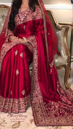 a woman in a red sari sitting on a couch