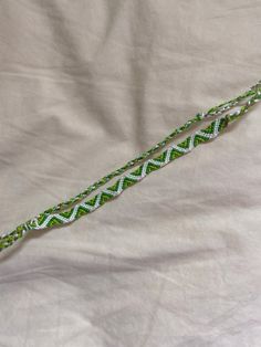 a green and white rope laying on top of a bed