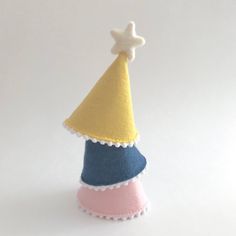 a small felt party hat with a star on top, sitting in front of a white background