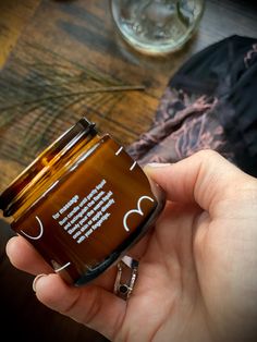 a person holding a brown jar with some writing on it