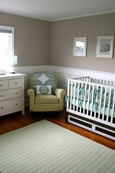 a baby's room with a crib, dresser and chair in the corner