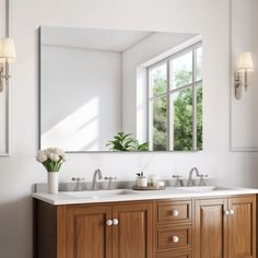 a bathroom vanity with two sinks and a large mirror above it, in front of a window