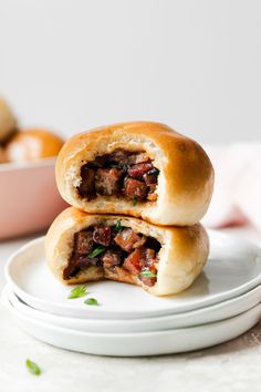 two sausage rolls stacked on top of each other, one cut in half and sitting on plates