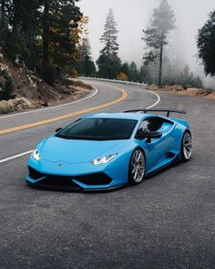 a blue sports car driving down the road