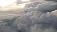 an airplane is flying high above the clouds