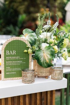 a table topped with vases filled with flowers and greenery