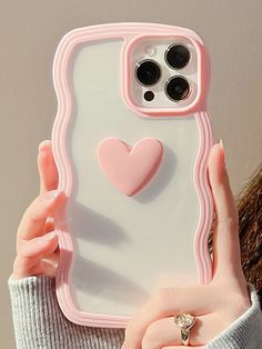 a woman holding up a phone case with a heart on it