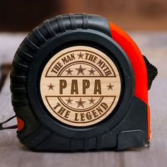 an orange and black tape measure with the words papa on it