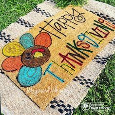 a welcome mat with a turkey on it is sitting in the grass and says happy thanksgiving