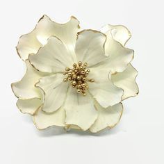 a white and gold flower brooch on a white background with clipping for text